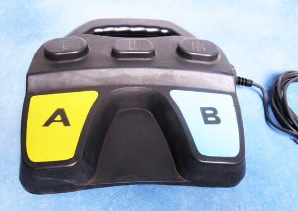 A black and yellow remote control sitting on top of a table.