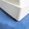 A close up of the corner of a white sink.
