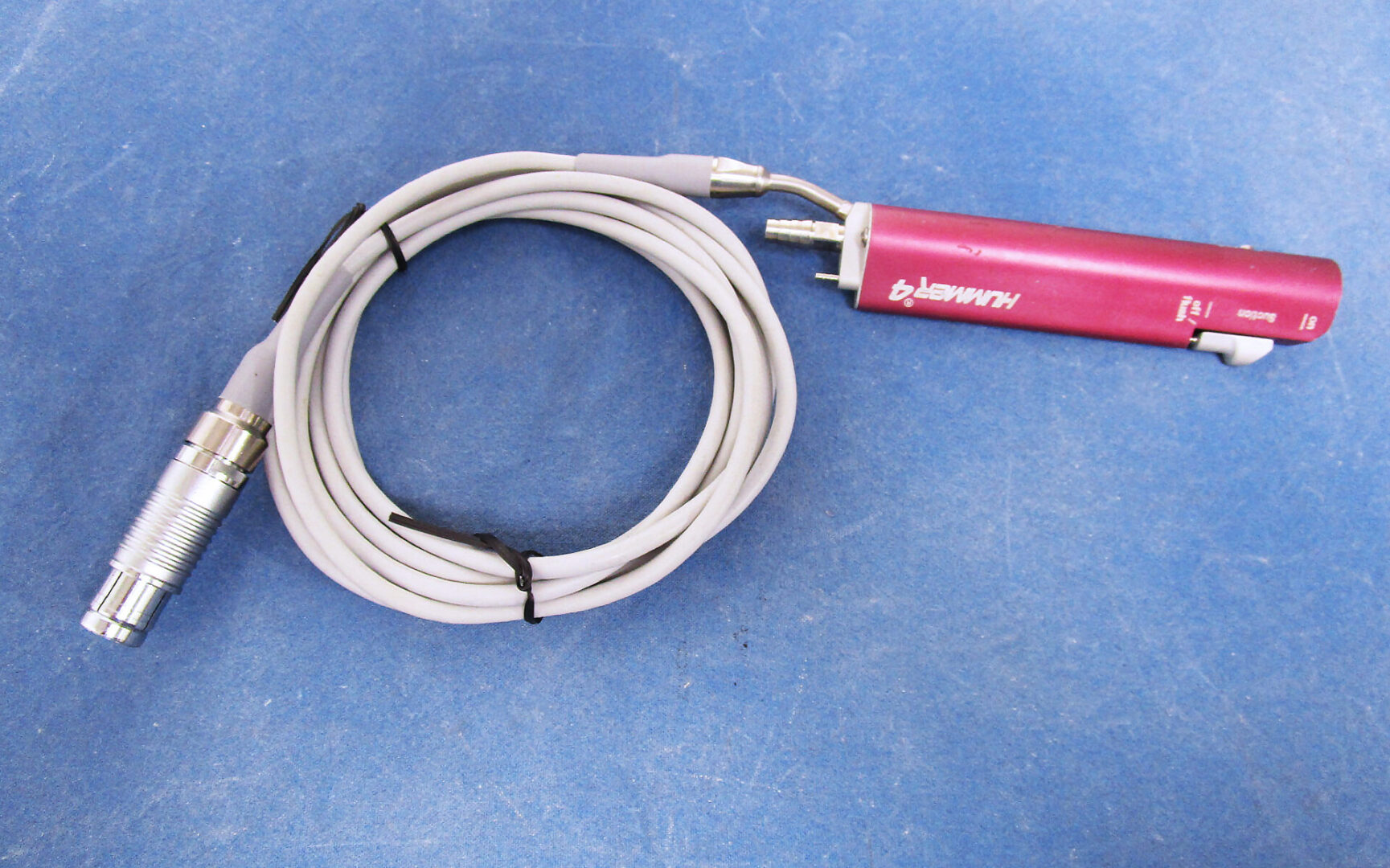 A pink and white cable on top of blue background.