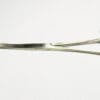 A pair of surgical scissors on a white surface.