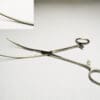 A pair of surgical scissors on a white surface.