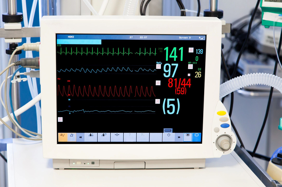 A monitor with an ecg screen and other medical equipment.