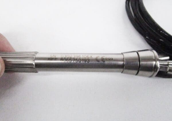 Silver medical instrument with serial number.